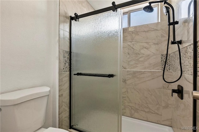 full bath with a tile shower and toilet