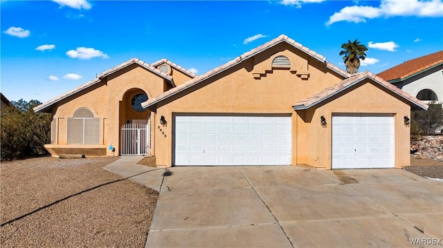 single story home featuring a garage, concrete driveway, a tile roof, and stucco siding