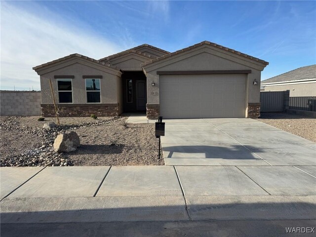 single story home with a garage, concrete driveway, stone siding, fence, and stucco siding