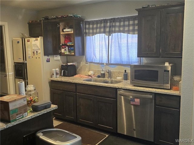 kitchen featuring a sink, open shelves, light stone countertops, and appliances with stainless steel finishes