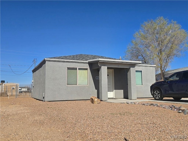 view of front facade featuring fence and stucco siding