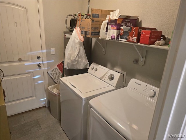 laundry room featuring washer and dryer, tile patterned floors, laundry area, and a textured wall