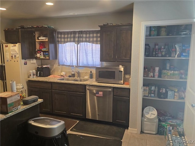 kitchen featuring dark brown cabinetry, appliances with stainless steel finishes, and a sink