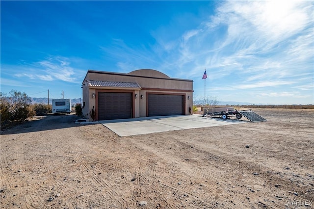 garage featuring concrete driveway