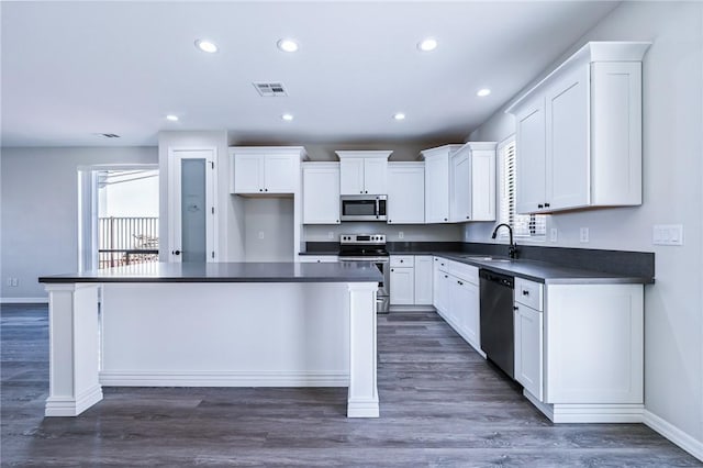6102 S Scorpion Ln, Fort Mohave, AZ 86426 - kitchen with stainless steel appliances, dark countertops, a center island, white cabinets, and recessed lighting