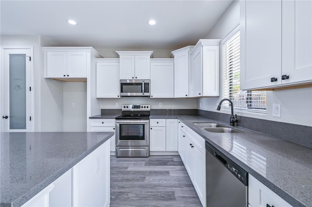 6102 S Scorpion Ln, Fort Mohave, AZ 86426 - kitchen with stainless steel appliances, white cabinets, dark stone countertops, recessed lighting, and wood finished floors