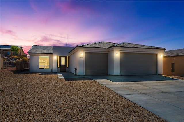 6102 S Scorpion Ln, Fort Mohave, AZ 86426 - view of front of house featuring a garage, driveway, stucco siding, and a tile roof