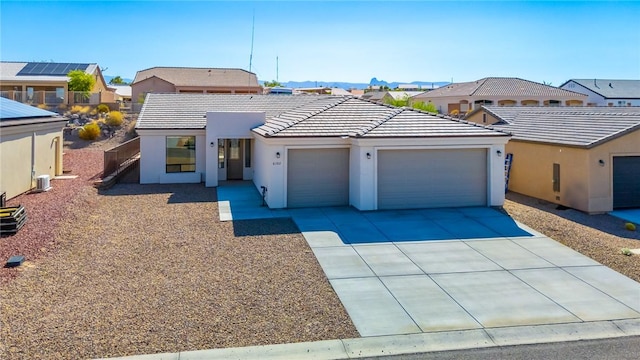 6102 S Scorpion Ln, Fort Mohave, AZ 86426 - view of front of property with an attached garage, stucco siding, concrete driveway, a tiled roof, and a residential view