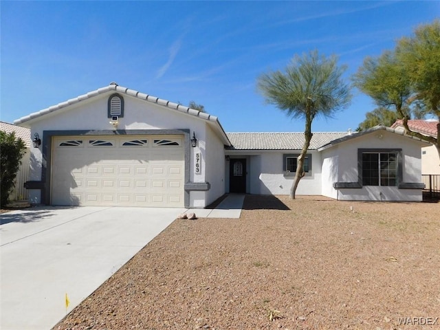 ranch-style home featuring a garage, concrete driveway, a tiled roof, and stucco siding