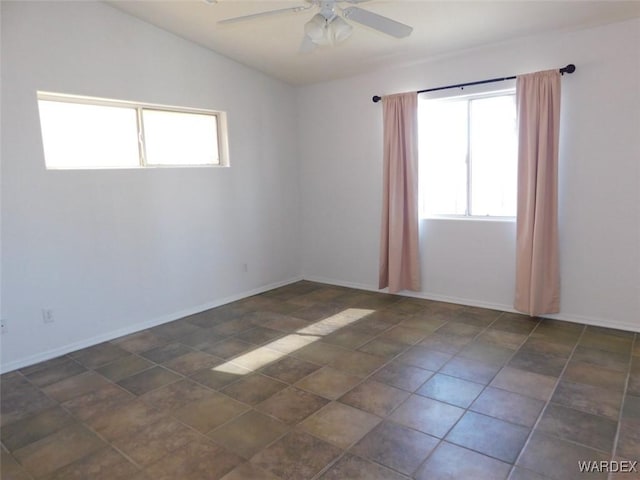 spare room with lofted ceiling, baseboards, and a ceiling fan