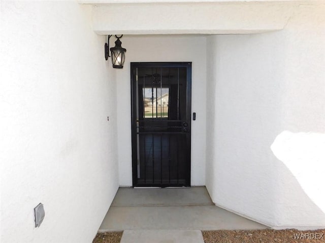 doorway to property featuring stucco siding