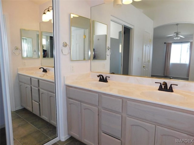 bathroom with double vanity, a ceiling fan, and a sink