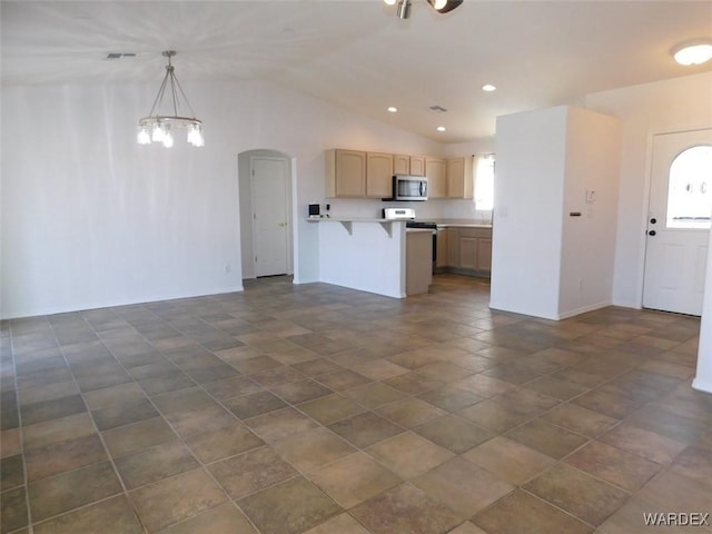 kitchen with stainless steel microwave, open floor plan, a peninsula, light countertops, and a kitchen bar