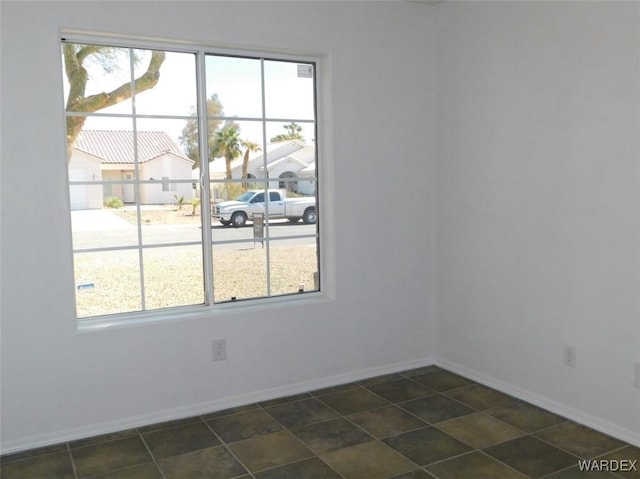 unfurnished room featuring baseboards