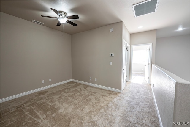 unfurnished room featuring light carpet, ceiling fan, visible vents, and baseboards