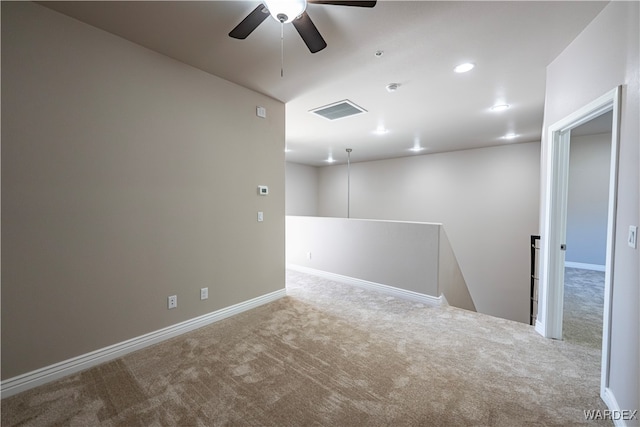 spare room with baseboards, visible vents, and light colored carpet