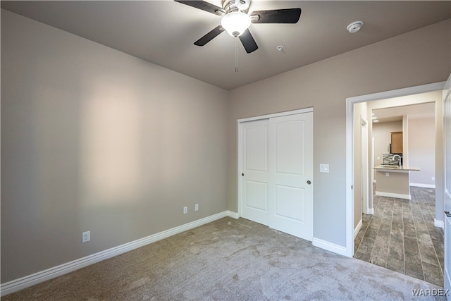 unfurnished bedroom featuring a closet, carpet flooring, ceiling fan, and baseboards