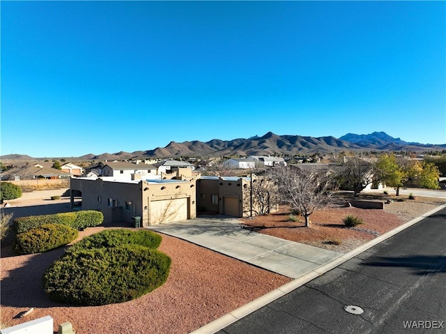 exterior space with stucco siding, an attached garage, a mountain view, a residential view, and driveway