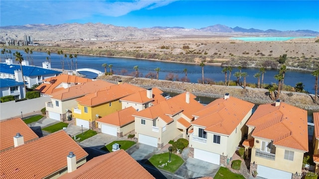 drone / aerial view featuring a water and mountain view and a residential view