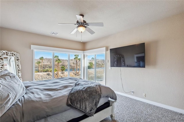 carpeted bedroom with access to exterior, visible vents, baseboards, and multiple windows