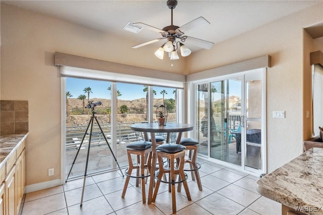 dining area with a ceiling fan, visible vents, baseboards, and light tile patterned floors