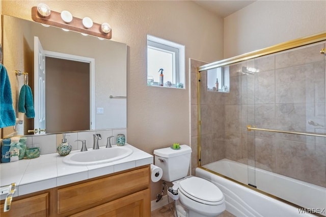 bathroom featuring shower / bath combination with glass door, vanity, and toilet