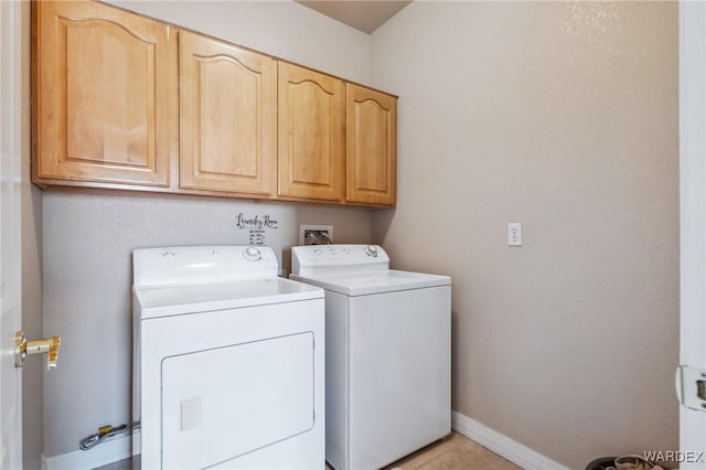 clothes washing area with washing machine and dryer, cabinet space, and baseboards