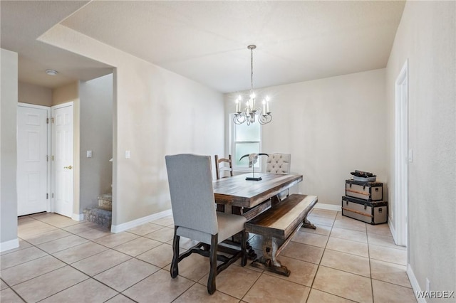 dining space featuring light tile patterned flooring, a notable chandelier, and baseboards