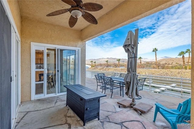 view of patio with ceiling fan, outdoor dining area, and a mountain view