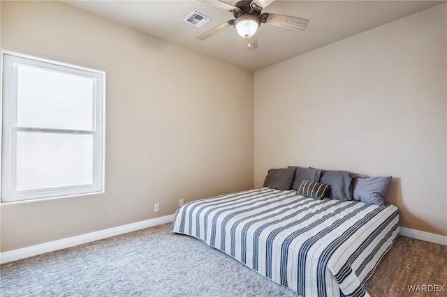 carpeted bedroom featuring a ceiling fan, visible vents, and baseboards