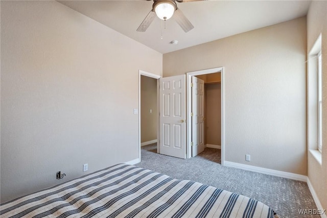 unfurnished bedroom with a walk in closet, carpet flooring, and baseboards