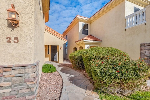 property entrance with a tiled roof and stucco siding