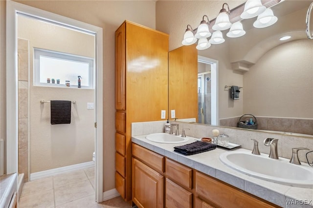 full bathroom featuring tile patterned flooring, a shower with door, a sink, and double vanity