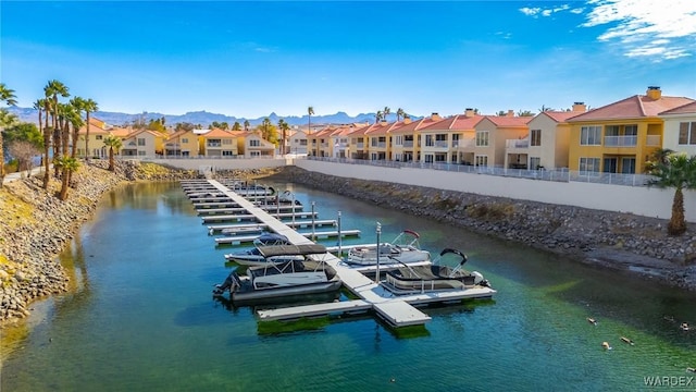 view of dock with a residential view and a water and mountain view