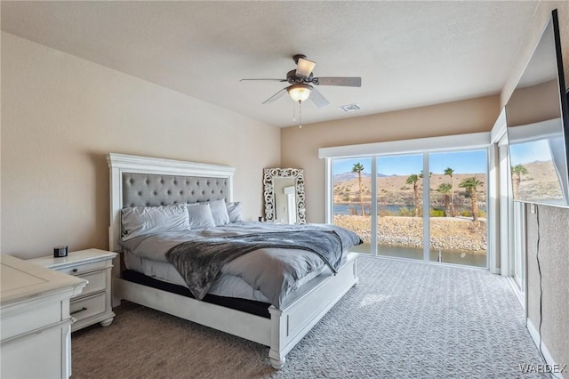 bedroom featuring ceiling fan, dark carpet, visible vents, and access to exterior