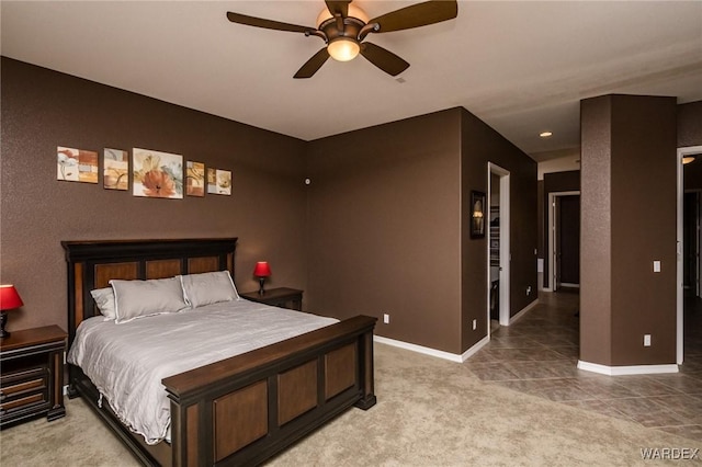 bedroom with light tile patterned floors, ceiling fan, baseboards, and light colored carpet