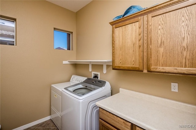 laundry area featuring dark tile patterned flooring, cabinet space, independent washer and dryer, and baseboards