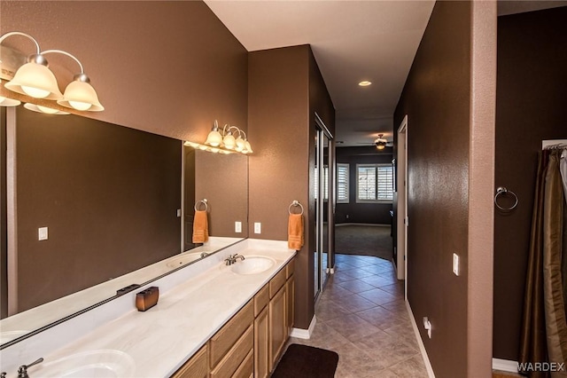 bathroom with a ceiling fan, tile patterned floors, a sink, and double vanity