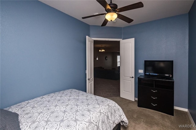 bedroom featuring ceiling fan, baseboards, and dark colored carpet