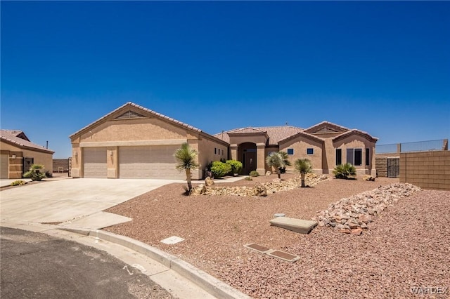 mediterranean / spanish house featuring concrete driveway, a tiled roof, an attached garage, fence, and stucco siding