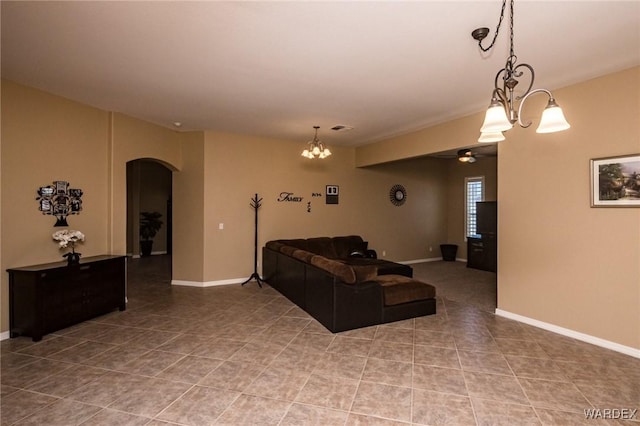 living room with arched walkways, a notable chandelier, visible vents, baseboards, and tile patterned floors