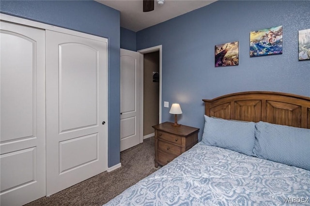 bedroom featuring baseboards, a ceiling fan, dark colored carpet, and a closet