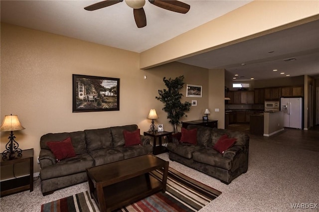 living area featuring a ceiling fan and baseboards