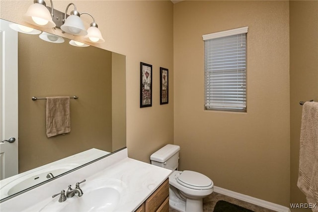 bathroom with toilet, baseboards, a chandelier, and vanity