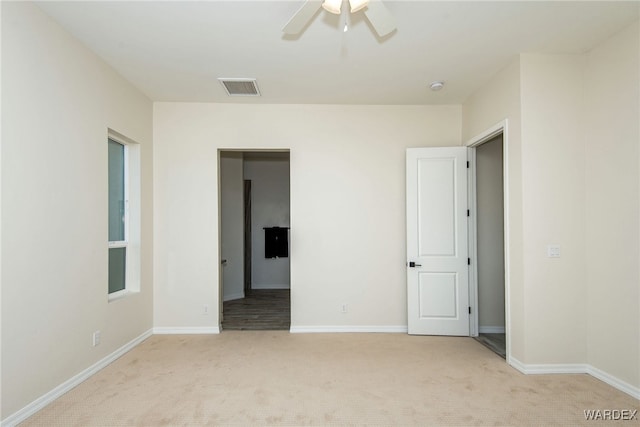 unfurnished bedroom featuring light colored carpet, visible vents, and baseboards