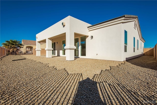 back of house with a patio area, a fenced backyard, and stucco siding