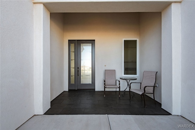 entrance to property with a patio area and stucco siding