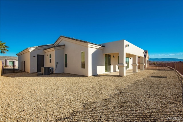 rear view of house featuring central AC, a patio, fence, and stucco siding