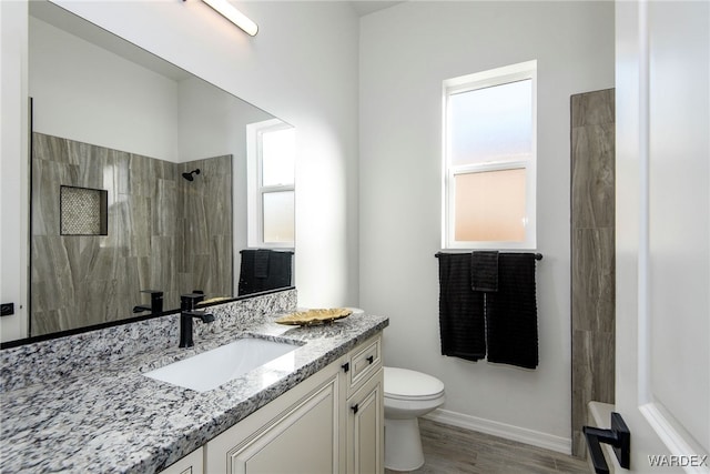 full bathroom featuring a walk in shower, toilet, wood finished floors, vanity, and baseboards