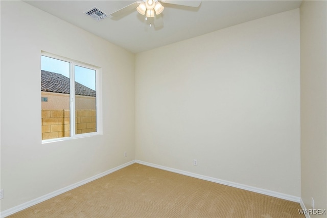 spare room featuring baseboards, visible vents, ceiling fan, and light colored carpet